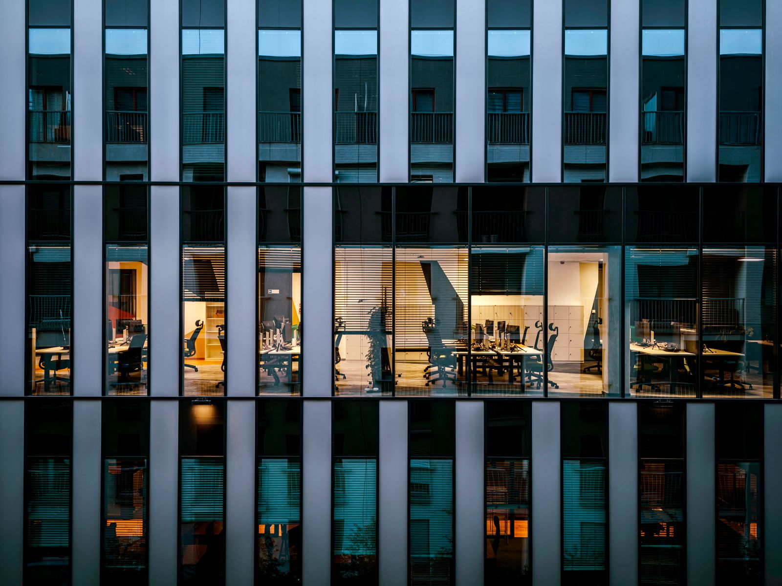 Modern glass office building lit up in the evening